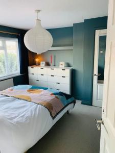 - une chambre avec un grand lit et un mur bleu dans l'établissement Whitstable contemporary cosy home with parking, à Kent