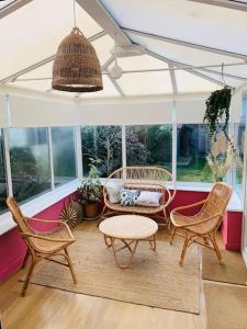 a screened in porch with chairs and a table at Whitstable contemporary cosy home with parking in Kent