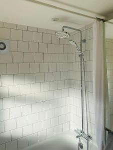 y baño con bañera y ducha con cortina de ducha. en Whitstable contemporary cosy home with parking, en Kent