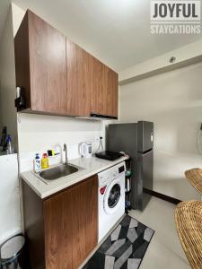 eine Küche mit einer Spüle und einer Waschmaschine in der Unterkunft Condo with resort-like living, everyday in Lapu Lapu City