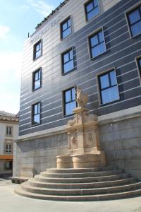 a large stone building with a statue of a man on top of it at Hotel José Régio in Portalegre