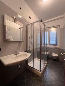 a bathroom with a sink and a shower and two toilets at Hotel Parma in Milan