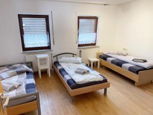 a room with three beds and two windows at Gemütliche Apartments mit Balkon in Niederstotzingen