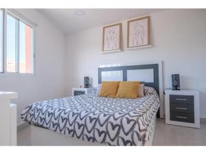 1 dormitorio con 1 cama con edredón blanco y negro en costa sur, en Vinarós