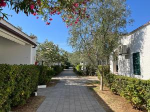 una passerella accanto a un edificio bianco e alberi di Villaggio Almar a Vieste