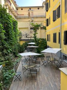 a group of tables and chairs with umbrellas in a courtyard at Hotel Parma in Milan