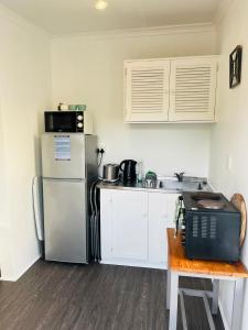 a small kitchen with a refrigerator and a table at Settlers Valley Cottage in Port Elizabeth