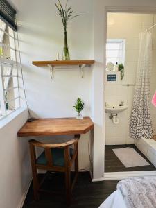 a small bathroom with a table and a sink at Settlers Valley Cottage in Port Elizabeth