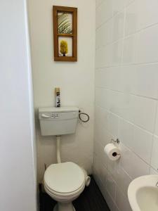 a bathroom with a white toilet and a sink at Settlers Valley Cottage in Port Elizabeth