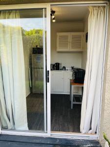 an open sliding glass door with a kitchen behind it at Settlers Valley Cottage in Port Elizabeth