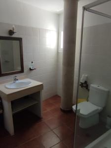a bathroom with a sink and a toilet and a mirror at CASA LA TAHONILLA in Tías