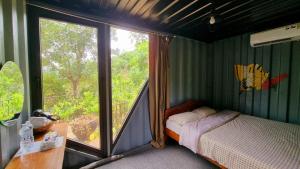 a bedroom with a bed and a large window at YesHue Eco in Hue