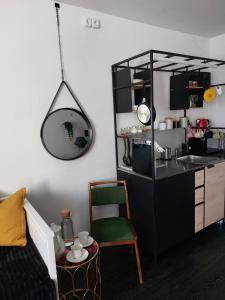 um quarto com uma cozinha com uma mesa e um espelho em Rooms Silesia em Katowice