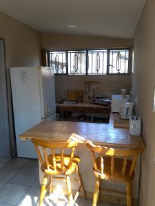 a kitchen with a wooden table and two chairs at Angela's Guest House in Marico-Wes
