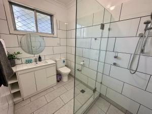 a bathroom with a toilet and a glass shower at Jacaranda Cottage in Broadwater +28 photos