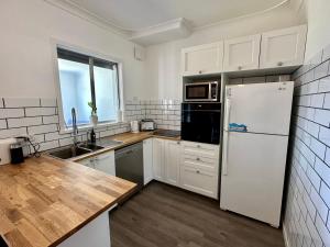 a kitchen with white appliances and a white refrigerator at Jacaranda Cottage in Broadwater