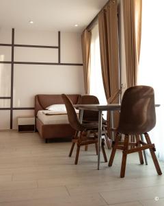 een kamer met 2 stoelen en een tafel en een bed bij Kronos Hotel in Durrës