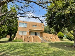 a large brick building with trees in front of it at Vaalaton in Oranjeville