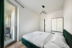 una camera con un letto e un grande specchio di Nova Sfera Green Apartment a Varsavia