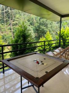 una mesa de ping pong en el balcón de una casa en Zerai private villa wayanad, en Vythiri