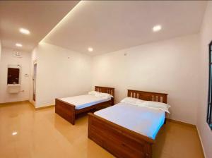 1 dormitorio con 2 camas y TV. en Zerai private villa wayanad, en Vythiri