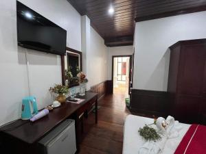 a living room with a television and a room with a bed at Villa Vieng Sa Vanh Hotel in Luang Prabang