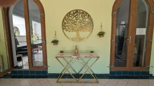 een tafel in een kamer met een boom aan de muur bij Casa do Palmeiral - Hoom B&B in Montes de Cima