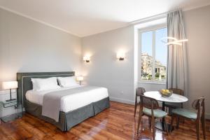pokój hotelowy z łóżkiem, stołem i krzesłami w obiekcie Liston Bliss Suite w Korfu