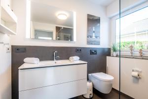 een badkamer met een witte wastafel en een toilet bij Tondernerstrasse 10 Haus Sauerland in Westerland