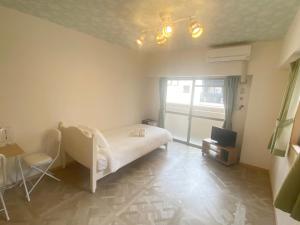 a bedroom with a bed and a table and a television at ピオーレ大手門501 in Susakiuramachi