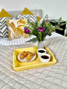 a tray with a plate of pastries and flowers on a bed at Chic Living At The Chancery in Leicester