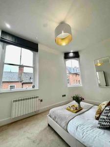 um quarto com uma cama e duas janelas em Chic Living At The Chancery em Leicester