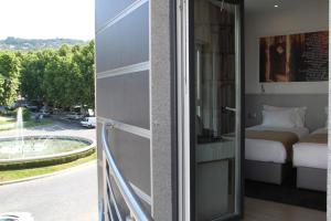 uma varanda com uma cama e vista para uma rua em Hotel José Régio em Portalegre