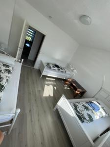 ein Wohnzimmer mit weißen Möbeln und Holzboden in der Unterkunft Ferien - Wohnung In Kassel Waldau Zentral in Kassel
