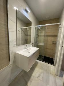 a white bathroom with a sink and a shower at La Casa de María Castaña in Seville