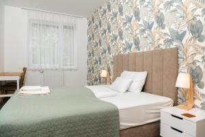 a bedroom with a bed with a green and white blanket at Dagály Apartments by UrbanRent in Budapest