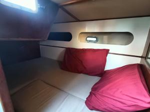 a small room with a red pillow on a plane at Barca a vela BREEZE in Formia