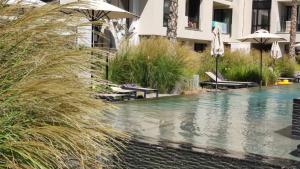 Azur Alegria Studio - free parking & pool في ساينت قسطنطين وهيلينا: مسبح وكراسي ومظلات بجانب مبنى