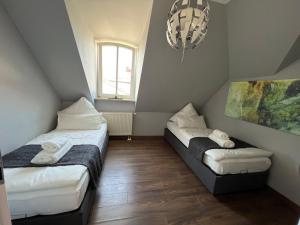 a small room with two beds and a window at Moderne Galerie-Wohnung! Zentral-A8-B17 WIFI in Gersthofen