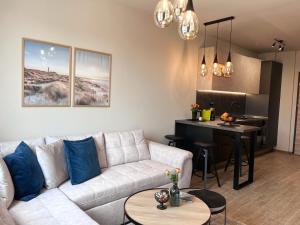 Azur Alegria Studio - free parking & pool في ساينت قسطنطين وهيلينا: غرفة معيشة مع أريكة بيضاء ومطبخ