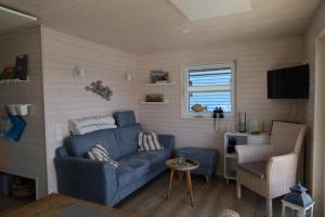 uma sala de estar com um sofá azul e uma cadeira em Hausboot Liliput em Stralsund