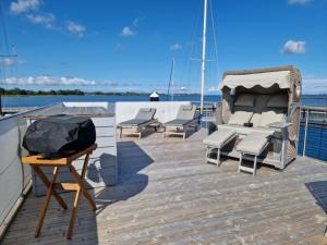 una terraza con sillas y una parrilla en un barco en Hausboot Liliput en Stralsund