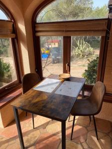 Casa del jabali - Tiny house في Tivissa: طاولة وكراسي خشبية أمام النافذة