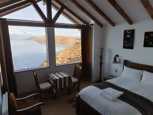 a bedroom with a bed and a large window at Sol y Luna ISLA DEL SOL in Comunidad Yumani