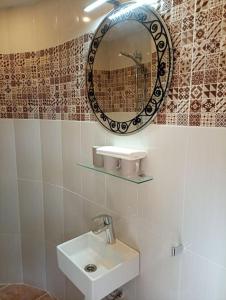 Casa del jabali - Tiny house في Tivissa: حمام مع حوض ومرآة على الحائط