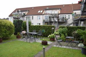 um jardim com uma mesa, cadeiras e edifícios em Hotel Mirage em Duisburg