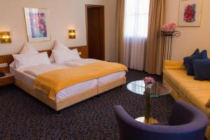 ein Hotelzimmer mit einem Bett und einem Sofa in der Unterkunft Stadthotel in Konstanz