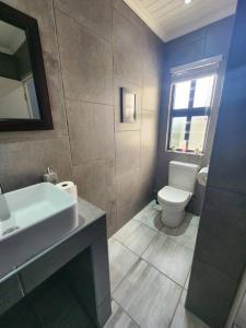 a bathroom with a white sink and a toilet at Hook Wine And Sinker in Langebaan +41 photos