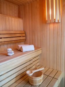a sauna with a bench and a basket in it at Golden Tulip La Baule in La Baule