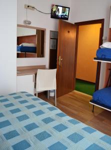 En eller flere senger på et rom på Hotel Midi